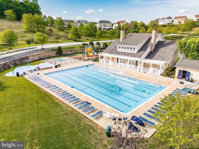 community pool with a residential view and a patio