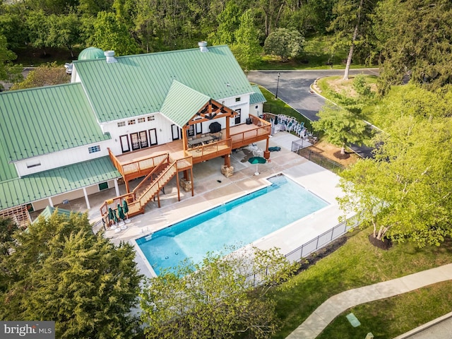 view of pool with a deck, stairs, fence, and a patio