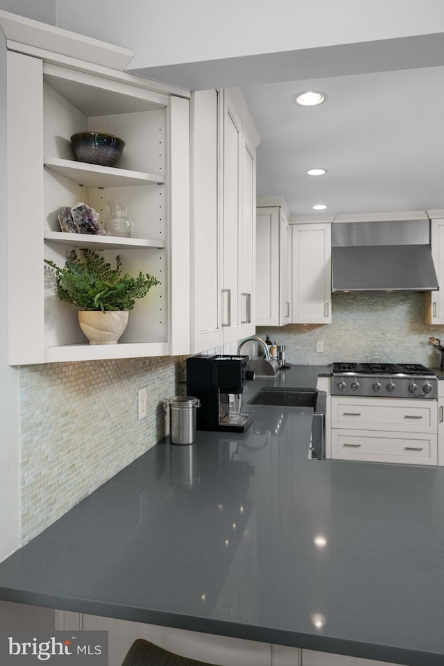 18 Beethoven Dr, Wilmington, DE 19807 - kitchen with wall chimney exhaust hood, stainless steel gas cooktop, a sink, white cabinetry, and decorative backsplash