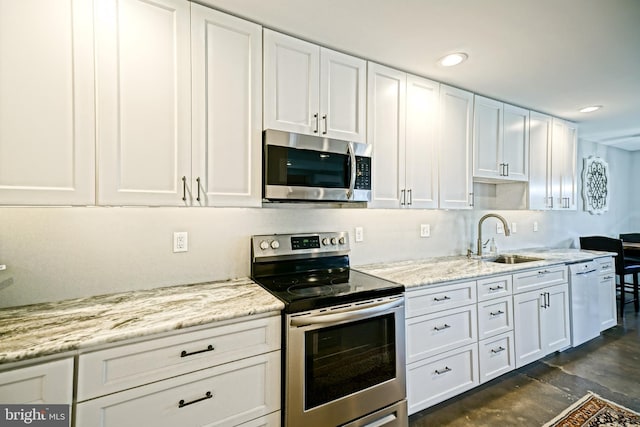 111 Seabright Way Unit E3, Rehoboth Beach, DE 19971 - kitchen featuring stainless steel appliances, a sink, white cabinetry, recessed lighting, and light stone counters
