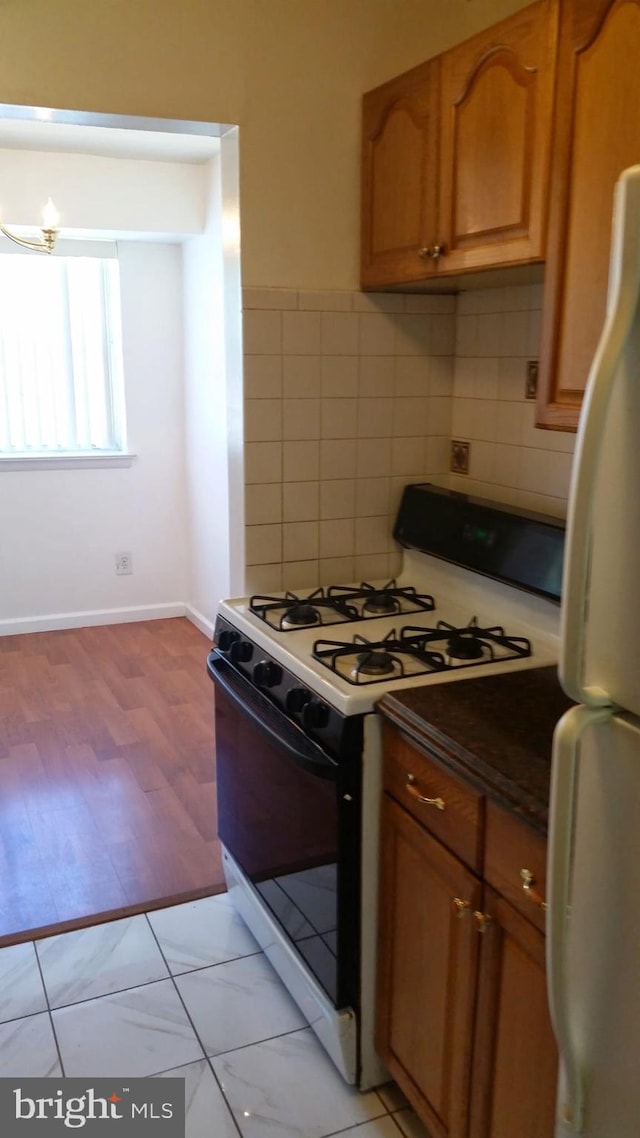 7093 Spring Garden Dr Unit 104, Springfield, VA 22150 - kitchen with white appliances, brown cabinets, dark countertops, light wood-type flooring, and baseboards
