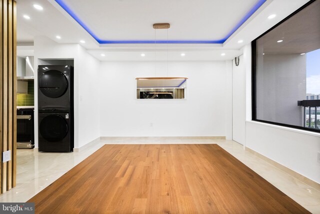 clothes washing area featuring estacked washer and dryer, recessed lighting, and baseboards