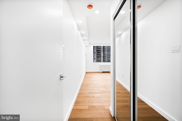 hallway featuring recessed lighting, light wood-type flooring, and baseboards