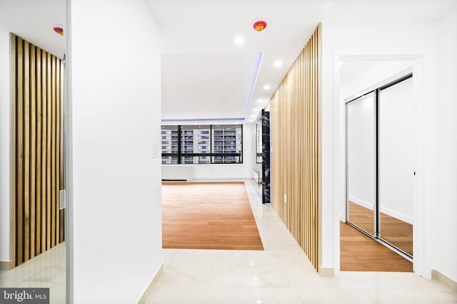 hallway with wood finished floors, baseboards, and recessed lighting
