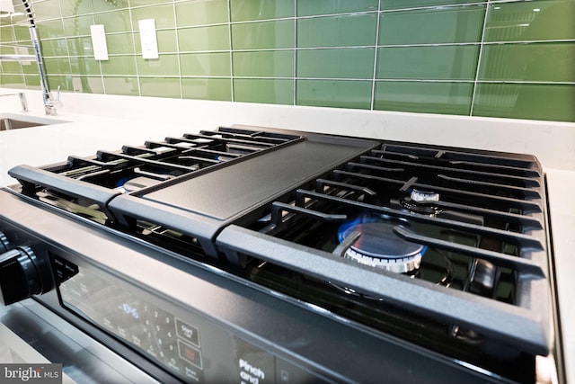 kitchen view of tasteful backsplash, stainless steel gas range oven, and stovetop
