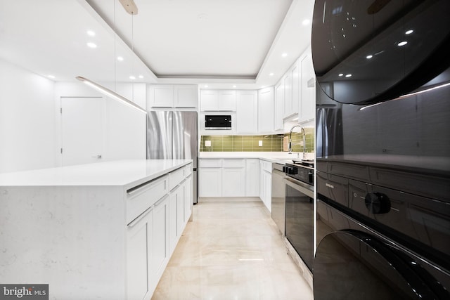 kitchen featuring appliances with stainless steel finishes, backsplash, white cabinets, light countertops, and recessed lighting