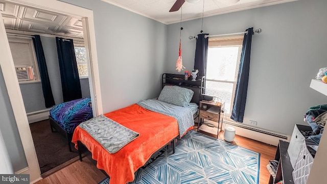 648 E 3rd St, Bloomsburg, PA 17815 - bedroom featuring wood finished floors, multiple windows, a baseboard radiator, and crown molding