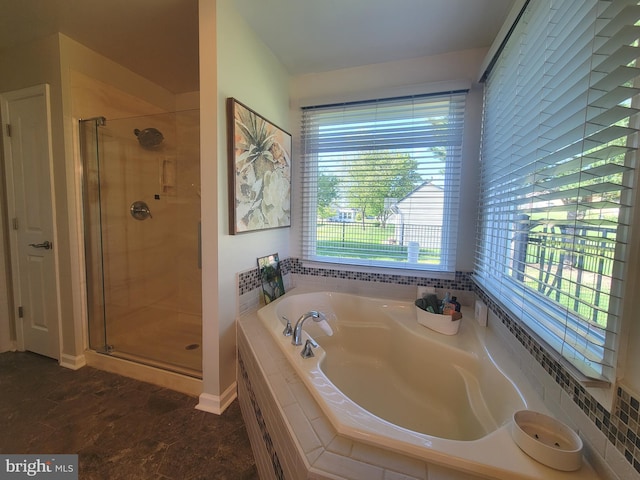 bathroom with a stall shower and a garden tub