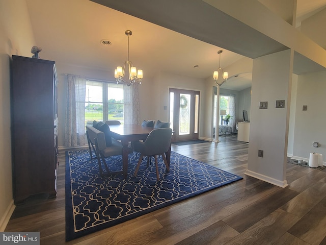dining room featuring a chandelier, baseboards, dark wood-style flooring, and lofted ceiling