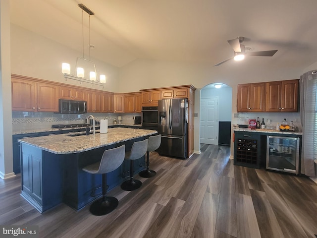 kitchen with stainless steel fridge, wine cooler, black oven, dark wood finished floors, and high vaulted ceiling