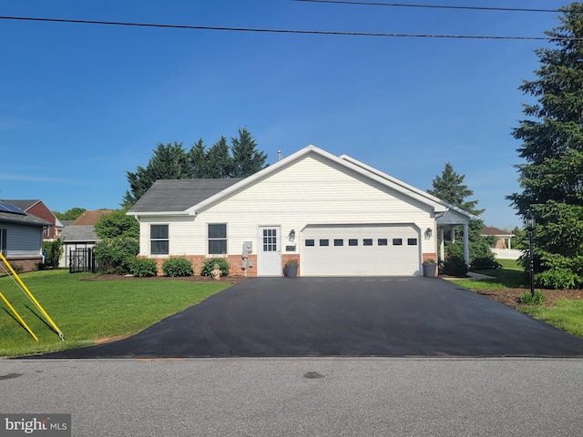 single story home featuring driveway, an attached garage, brick siding, and a front lawn