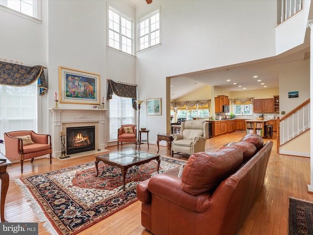 1517 Brookdale Ct, Winchester, VA 22601 - living room with a high ceiling, a fireplace with flush hearth, light wood-style floors, and stairway