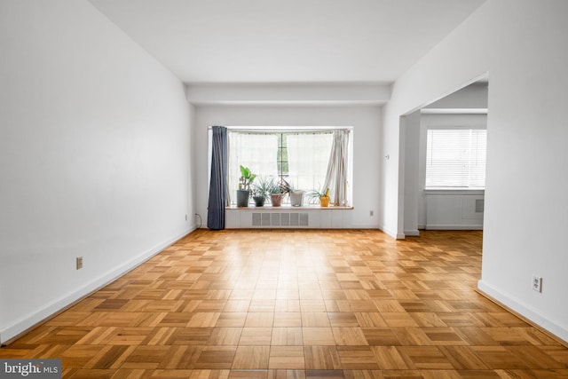 spare room featuring baseboards and healthy amount of natural light