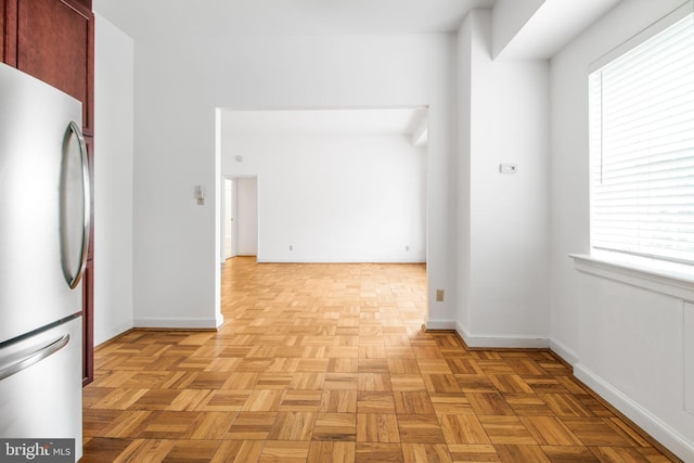 kitchen featuring freestanding refrigerator, plenty of natural light, and baseboards