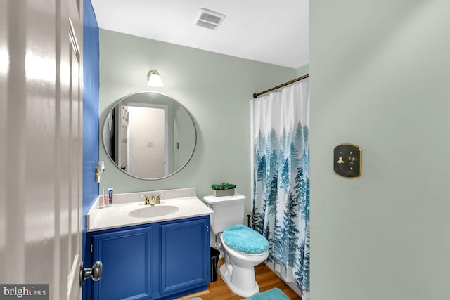 bathroom with toilet, wood finished floors, vanity, and a shower with shower curtain