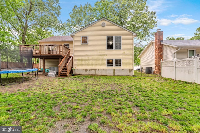 rear view of house with a trampoline, stairway, a deck, and central air condition unit