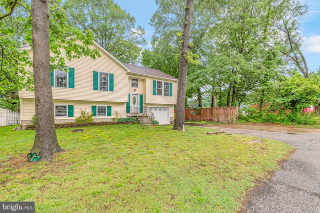 split foyer home with an attached garage and asphalt driveway