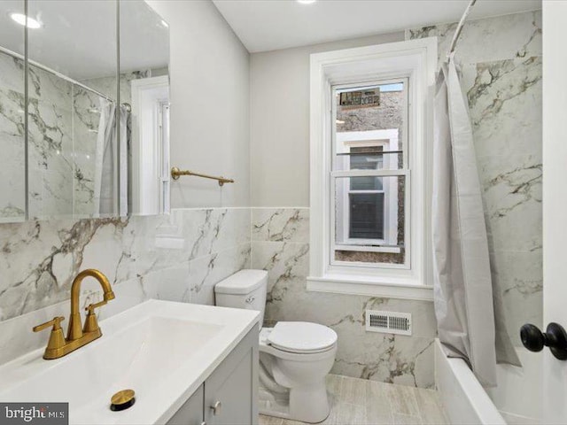 full bath with tile walls, toilet, marble finish flooring, shower / bathtub combination with curtain, and vanity