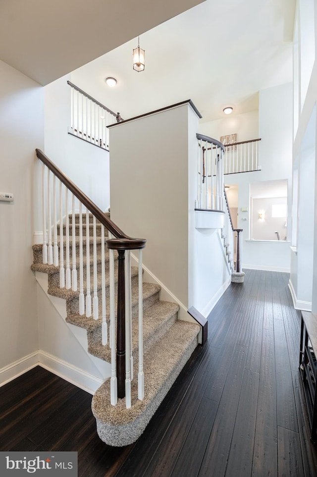 staircase with wood-type flooring and baseboards