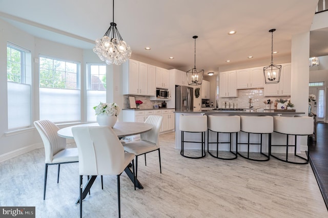 dining room with a chandelier, light wood-style flooring, baseboards, and recessed lighting