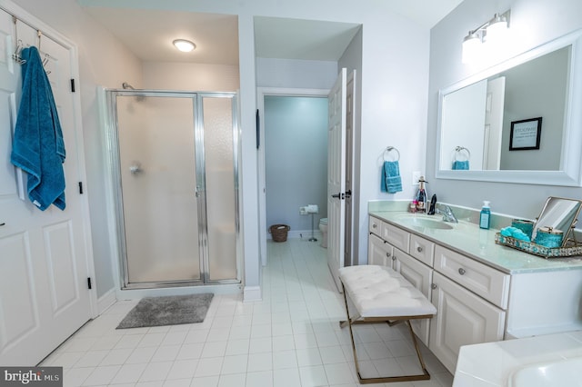 full bath with a shower stall, toilet, vanity, baseboards, and tile patterned floors