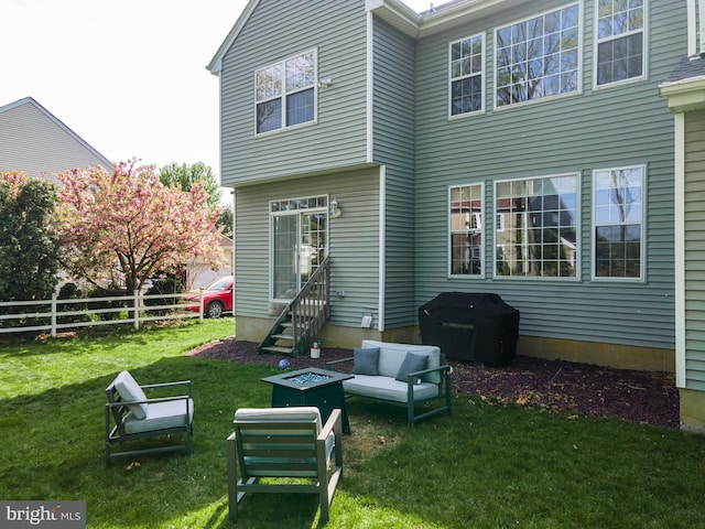 rear view of property featuring entry steps and an outdoor living space with a fire pit