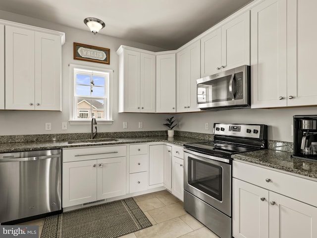 166 Spring Dale Ln, Felton, DE 19943 - kitchen with stainless steel appliances, a sink, white cabinetry, dark stone countertops, and light tile patterned flooring