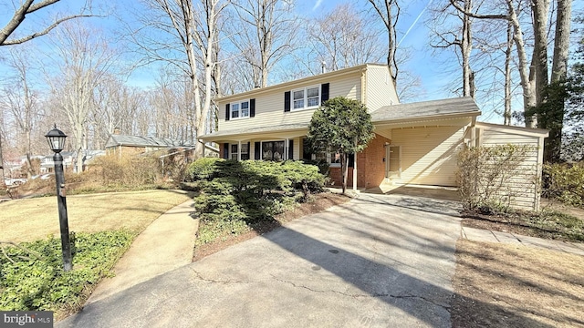 traditional home featuring concrete driveway, brick siding, and an attached carport
