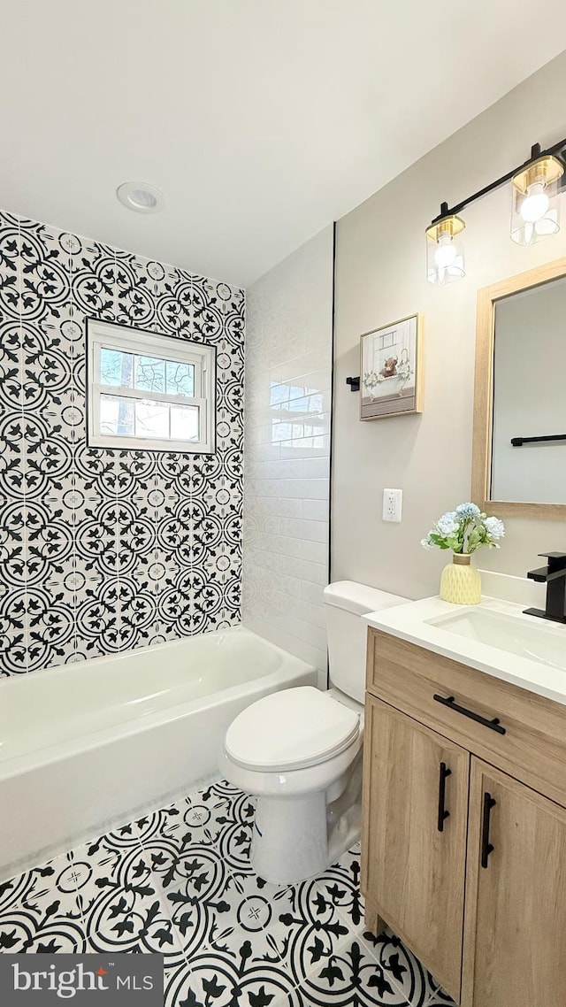 bathroom with toilet, vanity, washtub / shower combination, and tile patterned floors
