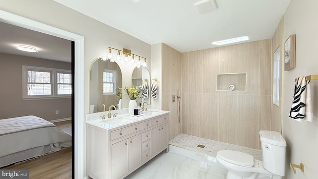 full bathroom featuring toilet, double vanity, and tiled shower
