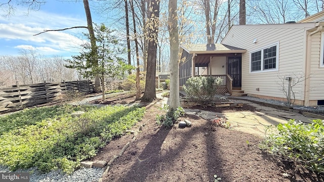 view of yard with fence and a sunroom