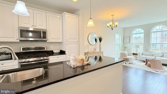 12515 Rustic Rock Ln, Beltsville, MD 20705 - kitchen with stainless steel appliances, white cabinetry, decorative light fixtures, a chandelier, and a sink