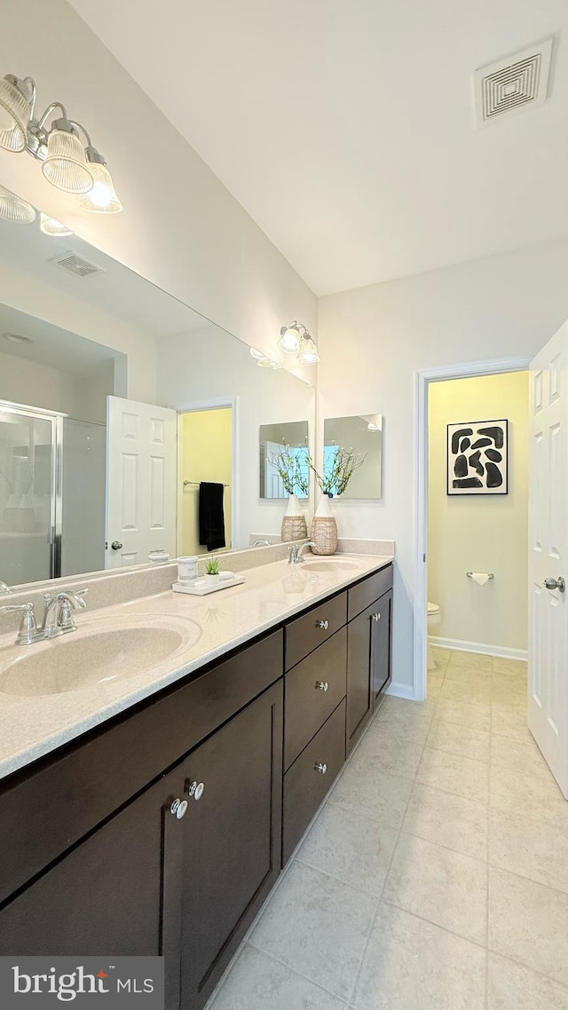 12515 Rustic Rock Ln, Beltsville, MD 20705 - full bathroom featuring double vanity, a shower stall, toilet, tile patterned floors, and baseboards