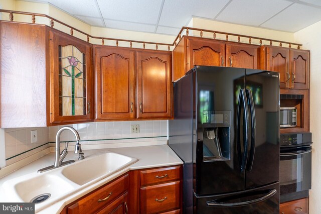 506 W 3rd St, Birdsboro, PA 19508 - kitchen featuring black appliances, a sink, light countertops, brown cabinetry, and decorative backsplash