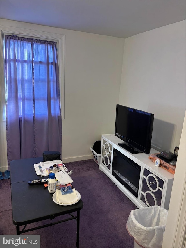 living room with dark colored carpet and baseboards