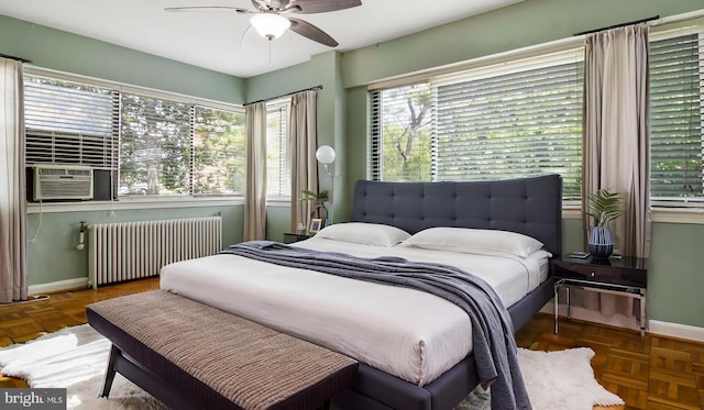 bedroom with radiator, baseboards, cooling unit, and a ceiling fan