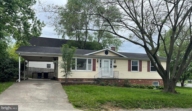 view of front of house featuring driveway, an attached carport, a front yard, and a chimney
