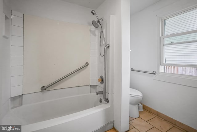 full bath featuring toilet, tile patterned flooring, baseboards, and shower / tub combination