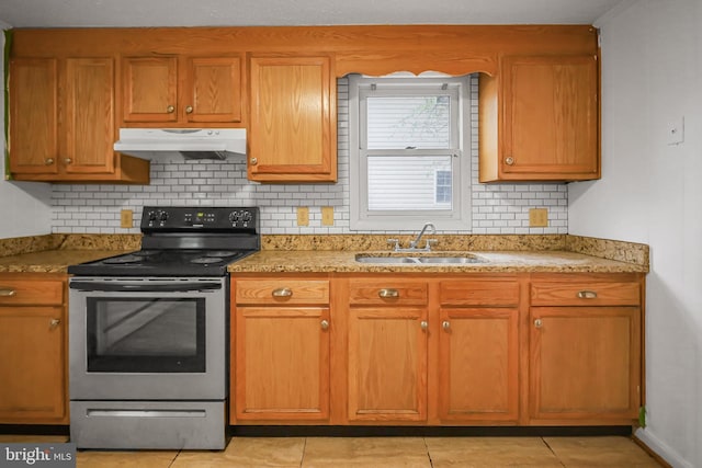 kitchen with stainless steel electric range oven, under cabinet range hood, a sink, backsplash, and light tile patterned floors