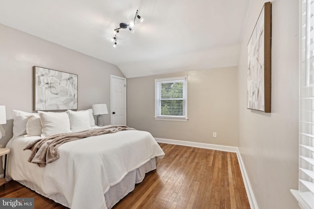 4850 Eastern Ave NE, Washington, DC 20017 - bedroom featuring hardwood / wood-style floors, baseboards, and vaulted ceiling