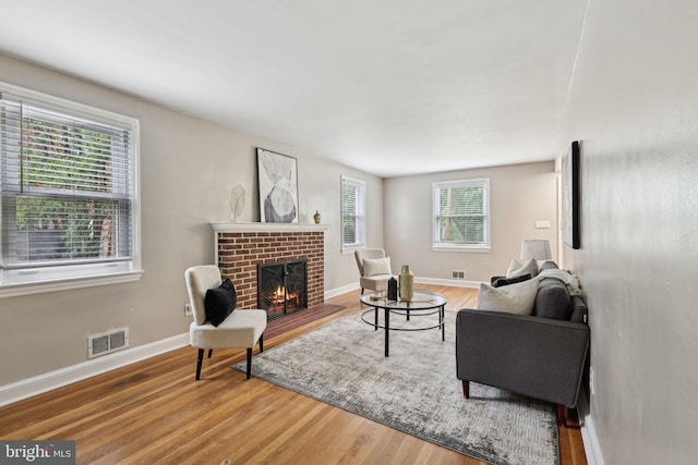 4850 Eastern Ave NE, Washington, DC 20017 - living room with wood finished floors, a brick fireplace, and baseboards