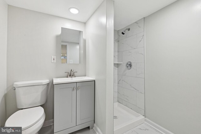 4850 Eastern Ave NE, Washington, DC 20017 - bathroom featuring marble look tile flooring, baseboards, vanity, toilet, and a stall shower