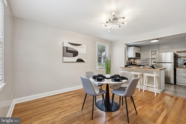 4850 Eastern Ave NE, Washington, DC 20017 - dining room featuring a chandelier, light wood-style flooring, and baseboards