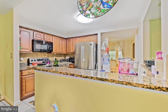 kitchen with stainless steel appliances, light stone countertops, light tile patterned floors, backsplash, and baseboards