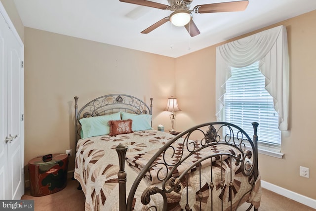 carpeted bedroom with ceiling fan and baseboards