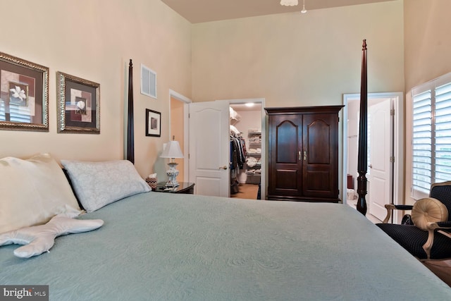 bedroom with a towering ceiling, a walk in closet, and a closet