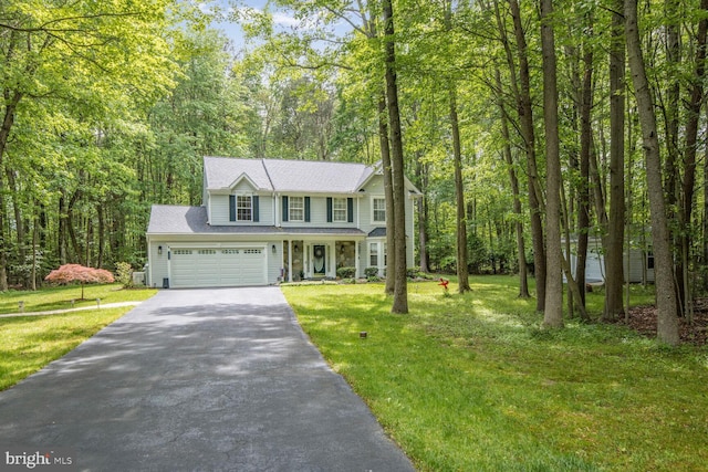 traditional home featuring driveway, a front yard, covered porch, and an attached garage