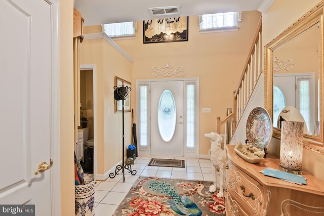 entryway with light tile patterned floors, stairs, and baseboards