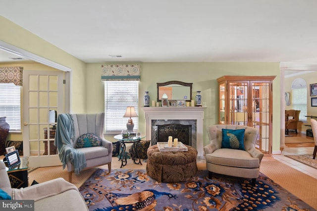 tiled living room featuring french doors and a high end fireplace