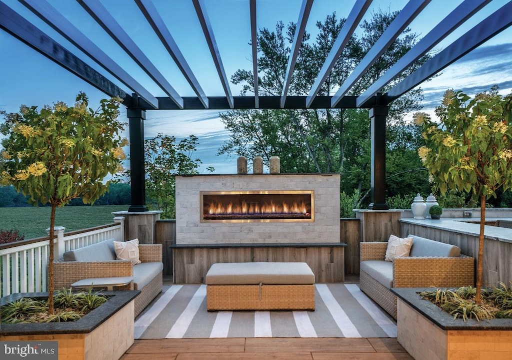 view of patio / terrace featuring a glass covered fireplace and a pergola